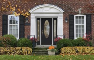An entry door with glass accents on a brick home.
